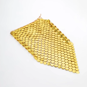 Close-up of gold metal sequin grid showing detailed circular scale connections and shiny texture