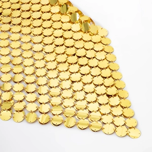 Detail shot of golden metal sequin mesh fabric with mirror finish for body jewelry