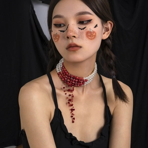 Detail of gothic choker with red drip tassels and blood-red beads for Halloween