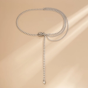 Silver multi-layer chain belt with heart pendant and adjustable buckle on tan background