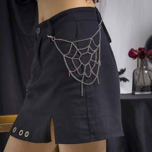 Dettaglio catena in argento a ragnatela su gonna di jeans nera stile gothic punk