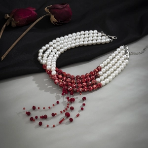Close-up of gothic choker featuring tiered white pearls and red blood-drop tassel beads