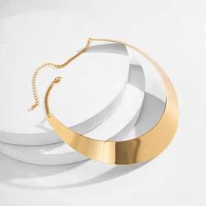 Minimalistisches goldene Punk-Halsband mit Halbmond-Anhänger auf weißem Sockel