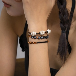 Detalle del conjunto de pulseras de Halloween con calavera y cuentas letras en la muñeca