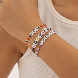 Detailopname van Halloween kralenarmbanden met BOO en SPOOKY bedeltjes om de pols