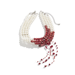 Close-up of layered gothic choker with red marble beads and pearl tassel detail