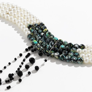 Close-up of gothic pearl choker showing multi-layer beaded tassels and textured stone charms