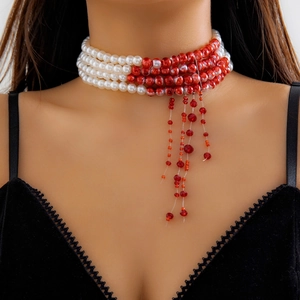 Detail of gothic multilayer pearl choker with red drip fringe on a lace collar