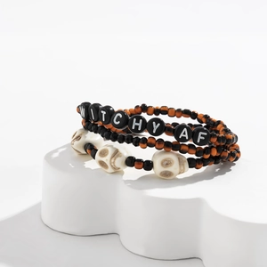 Detalle del set de tres pulseras elásticas con letras WITCHY AF y cuentas de calaveras