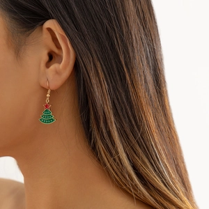Gros plan de boucles d'oreilles sapin de Noël en émail vert sur le mannequin