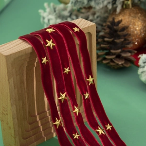 Detail van rood fluwelen lint met gouden sterren en feestelijke kerstdecoratie