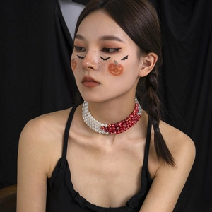 Close-up of Gothic choker featuring white pearls and red marbled blood-drop beads