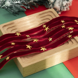 Detail van rood fluwelen lint met gouden sterren in een feestelijke kerstsetting
