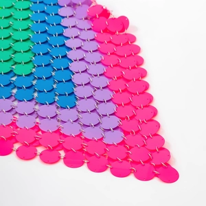 Macro detail of vibrant sequin tassel skirt with silver metal rings and disco party style