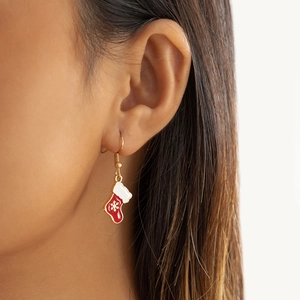 Détail de la boucle d'oreille botte de Noël rouge avec flocon blanc sur crochet doré
