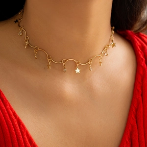 Detail van de gouden golfketting choker met kleine sterhangers en sprankelende strassteentjes