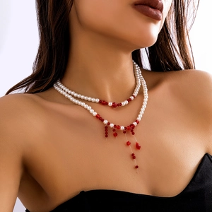 Detail of gothic choker with white pearls and red crystal bead fringe on a model