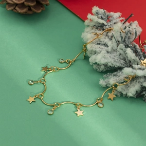 Detail van sterhangers en groene edelstenen op gouden ketting met feestdecor