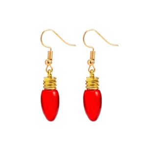 Gros plan de boucles d'oreilles ampoule rouge créatives avec crochets dorés sur blanc