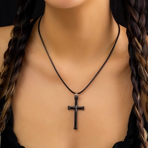 Nahaufnahme einer schwarzen Punk-Kreuzkette mit Nietendetails an einer Lederschnur