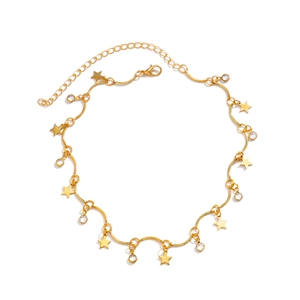 Detail van gouden sterhangers en kristallen op de elegante metalen truiketting