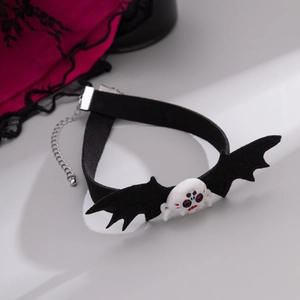 Dettaglio del choker gotico in velluto nero con ali di pipistrello e teschio bianco