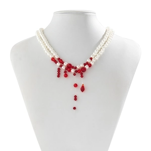 Detail of gothic pearl choker featuring red crystal blood drip tassels on a white display