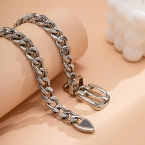 Silver chunky curb chain necklace with a belt buckle clasp on a modern display