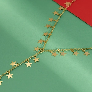 Detail van gouden sterrenketting op een feestelijke rood-groene achtergrond
