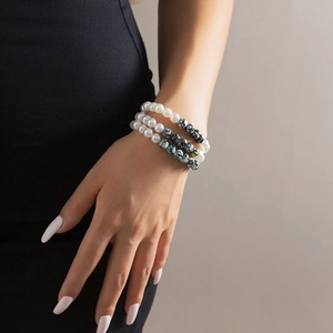 Close-up of triple-layered beaded bracelet with faux pearls and marble texture beads