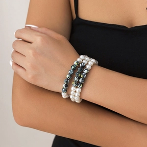 Detail of three-layer beaded bracelets set with pearls and ethnic patterned beads on wrist