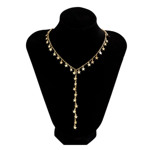 Gedetailleerde opname van een gouden sterrenketting met Y-vormige kwast op een zwart model