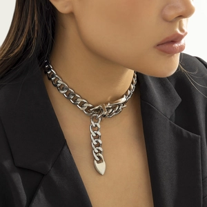 Silver link chain choker featuring a heart pendant worn by a model in a black blazer