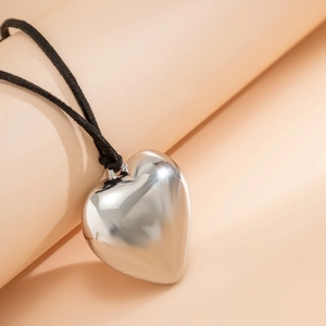 Close-up of polished silver heart pendant with an adjustable black cord necklace