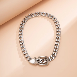 Silver curb chain necklace featuring a vintage belt buckle clasp on a nude background