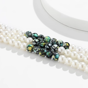 Detailed view of layered beaded choker with white pearls and marbled pattern beads