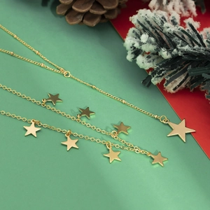 Detailopname van gouden sterrenkettingen met kerstversieringen en dennenappels