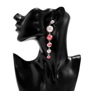 Macro detail of gothic drop fringe beads and white faux pearls on silver metal earrings