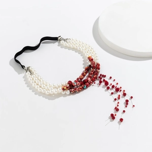 Gothic choker detail with white pearls, marble beads, and hanging red bead tassels