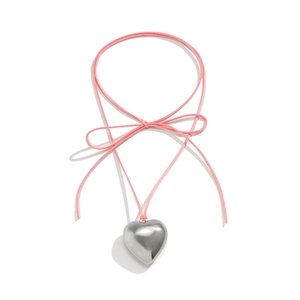 Detail of a polished silver heart pendant with a pink ribbon bow necklace on white background
