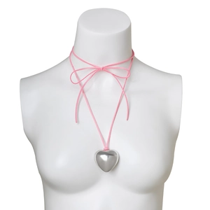 Detail of pink velvet cord choker with large polished silver heart pendant on white bust