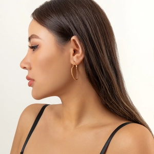 Side view of elegant golden heart-shaped hoop earrings with textured pearl details on a model