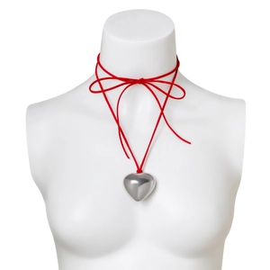 Detail of red choker necklace with silver heart pendant on a white mannequin head