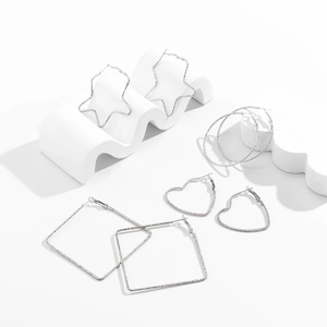 Detailed view of silver geometric earring set featuring stars, hearts, and square hoops