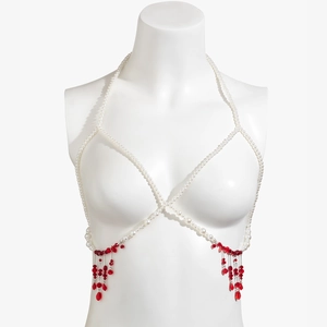 Detail of gothic pearl body chain featuring cascading red bead tassels on white bust