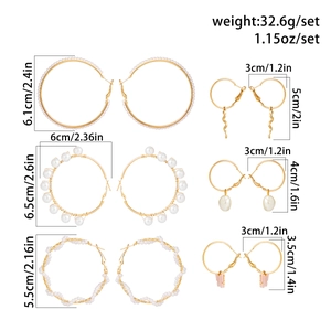 Detailed view of gold hoop earrings set with pearls and charms including butterfly and snake