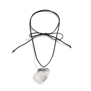 Detail of transparent resin heart pendant with black cord and elegant bow decoration