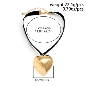 Detail of gold heart pendant choker with black fabric strap and lobster clasp adjustment