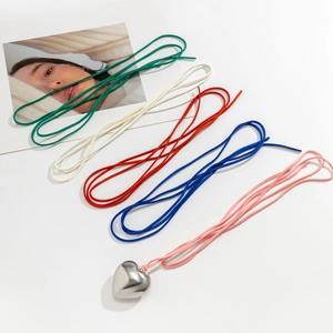 Flat lay of large heart pendants with colorful velvet cords in green, white, red, blue, and pink