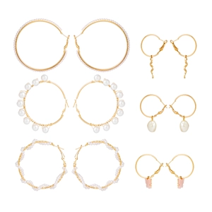 Detail view of 6 pairs gold hoop earrings set with faux pearls and butterfly charms